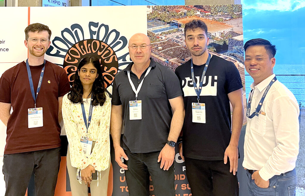 Five persons standing wearing name badges.